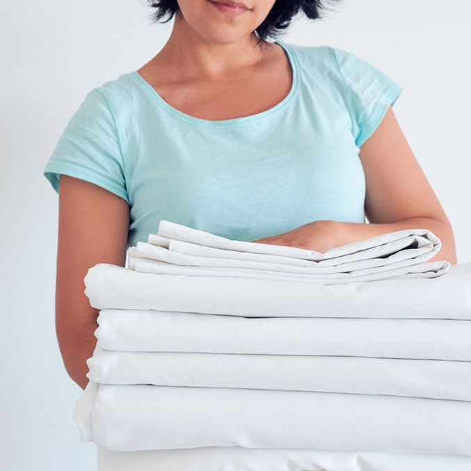 Woman holding clean linens after service by All Pro LInen in Boise, ID